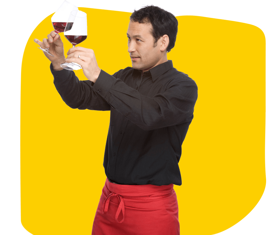 Wine  translation services, A winemaker checking the wine and pouring it from one glass to another, wearing a red cloth wrapped around his waist.