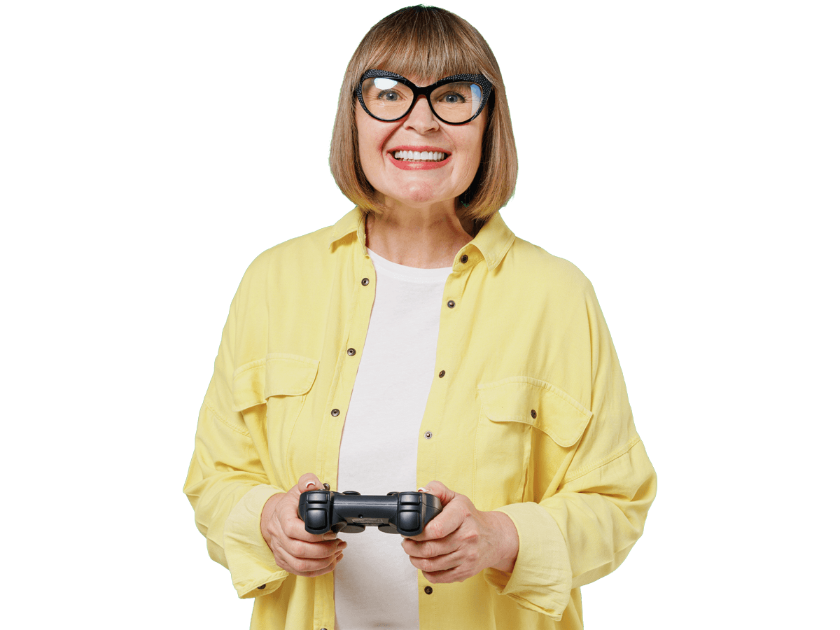 Gaming translation services, lderly smiling happy cool fun caucasian woman 50s in glasses yellow shirt hold in hand play pc game with joystick console 
